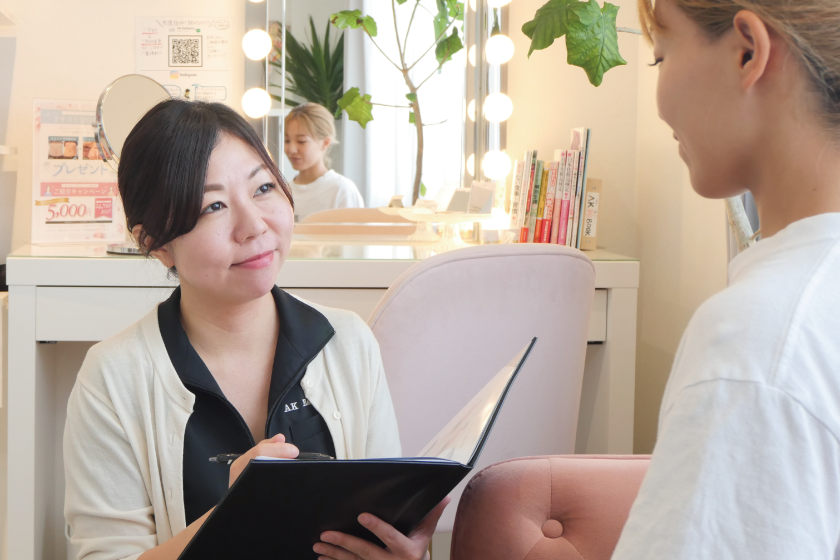 エステサロンでお客様の悩みをヒアリングする女性